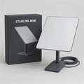 Starlink Mini-labelled box beside a white rectangular dish on a stand and a coiled cable.