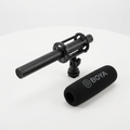 AI-generated unpacked view of a BOYA BM6060 shotgun microphone, suspension mount and foam windshield